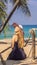 Vacation on tropical island. Woman in hat enjoying sea view from wooden bridge VERTICAL FORMAT for Instagram mobile