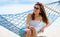 Vacation woman relaxing on beach in hammock on summer