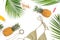 Vacations concept of pineapple fruits, palm leaves and bikini swimwear on white background. Flat lay, top view.