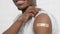 vaccinated African American man showing arm with medical plaster patch Plaster On Shoulder, black male after getting