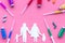 Vaccination as way to save healthy family. Syringe with colored vaccine near silhouette of family on pink background top