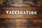 Vaccination concept. Inscription on dark wooden table background. Preventive vaccinations against Virus diseases