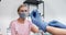 Vaccination concept. Senior patient woman watching nurse hands in gloves using syringe to give coronavirus vaccine shot.