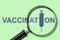 Vaccination. Inscription on a green background. Through a magnifying glass. Vaccination syringe icon Vaccination of humans against