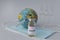 Vaccine in ampoule with syringe, toy globe  and three transparent ampoules with medicine on medical mask