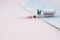 Vaccine bottle, syringe and disposable medical mask on white background.