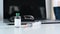 Vaccine bottle and syringes, laptop and glasses on doctor workplace.