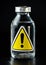 Vaccine bottle with yellow triangle exclamation mark sign on label, black background