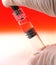 Vaccine in syringe body against red gradient