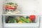 Vacuum bags with different vegetables in fridge, space for text. Food storage