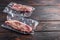 Vacuum packed meat , top blade beef steak on dark old wooden table,  side view space for text