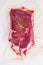 Vacuum packed organic beef meat   rump steak on white concrete  textured background, top view space for text