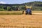 VALCHOV, CZECH REPUBLIC - JUNE 29: Combines harvesting grains and filling tractor trailer in summer on field June 29, 2017 in Valc