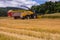 VALCHOV, CZECH REPUBLIC - JUNE 29: Combines harvesting grains and filling tractor trailer in summer on field June 29, 2017 in Valc