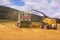 VALCHOV, CZECH REPUBLIC - JUNE 29: Combines harvesting grains and filling tractor trailer in summer on field June 29, 2017 in Valc