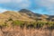 Valencia peak, Los Osos valley, green hills, and California native forest with beautiful cloudy sky on the background.