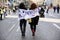 Valencia, Spain - March 8, 2020: Two women walk on their backs through the street during a feminist demonstration with the