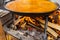 Valencian Paella being cooked on barbecue with lots of fine oak wood. Spanish typical food. Selective focus