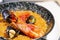 Valencian paella with rice, saffron and seafood served in a special pan