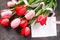 Valentine background or greeting card. Congratulatory sheet of paper with red and Ð¿Ð¸Ð½Ðº tulips on a dark stone background.