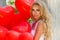 Valentine Beautiful girl with red balloons laugh, in the park. Beautiful happy young woman.