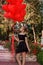 Valentine Beautiful young girl with red balloons laugh, in the park. Beautiful happy kid. Christmas party. Joyful little model