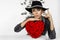 Valentine Beauty girl with red heart roses. Portrait of a young female model with gift and hat, isolated on background.