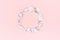 Valentine day background - blank wreath of silver eucalyptus leaves on pastel pink backdrop, top view, copy space.