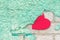 Valentine day background with red paper heart on a rustic green crumbling wall. heart is stuck on the stucco