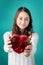 Valentine Day concept. Beautiful young smiling woman with gift in form of heart