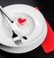 Valentine day dinner with table setting in red and elegant heart ornaments