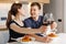 Valentine day romantic dinner at home. Happy couple smiling, clinking glasses and eating pasta with wine at kitchen