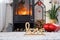 Valentine decor near fireplace stove with fire and firewood. Cozy home hearth in interior with potted plans, valentines day in