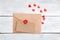 Valentine. envelope kraft paper and red hearts on a wooden background.
