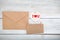 Valentine. envelope kraft paper and white wooden heart on a wood