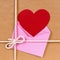 Valentine gift with red heart card or gift tag, brown paper package parcel background
