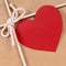 Valentine gift with red heart shape gift tag, brown paper package parcel background