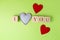 Valentine hearts of jeans and rustic alphabet blocks that spell out I Love You on greenery background. Top view. Copy