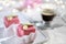 Valentine petit fours with marzipan icing and cream flowers. Espresso coffee in glass cup. Garland of lights on white