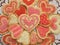 Valentine red, white, and pink iced heart cookies on doily, horizontal