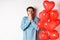 Valentine and relationship. Worried boyfriend panicking on lovers day, standing near red hearts balloons and gasping