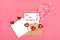 Valentine`s card - envelope, paper for notes, candles in the shape of a heart on a pink background Valentine`s day