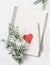 Valentine`s day background - clean blank notepad, flowers and a paper heart on white background, top view. Free space for text.