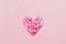 Valentine\\\'s Day background February 14th. Heart made of pink hearts confetti on pink background.