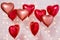 Valentine`s day background - group of red heart shaped balloons over brick wall