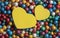 Valentine`s Day background. Multicolor small size thermocol decorative balls with two yellow hearts on top