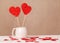 Valentine`s day background. Two heart-shaped candies in a white Cup, a scattering of small hearts on a white table