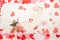 Valentine's day background - white, pink and red hearts arranged on white background with pink peonies and white envelope.