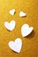 Valentine's Day background. White volumetric paper hearts on a golden background. Valentine's Day concept