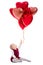Valentine`s day or birthday concept - cute baby girl and flying red balloons isolated on white